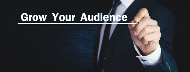 Man write Grow Your Audience text in screen.