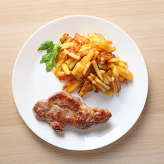 steak with fried potatoes top view