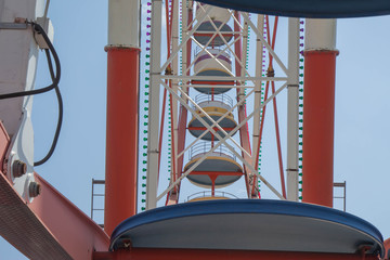 fragment A colourful ferris wheel. Brightly colored Ferris wheel against the blue sky