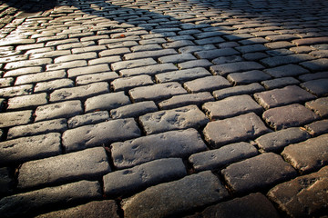 Cobblestone background with long shadows at sunset, London