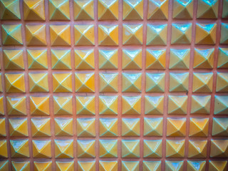 Fototapeta na wymiar Abstract ceramic wall tiles in the shape of pyramid background. Geometric pattern of pyramid shapes.