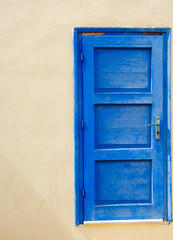 Obraz na płótnie Canvas blue seperated door at a wall in Sissi on Crete in Greece