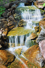 Fototapeta na wymiar waterfall over colored rocks