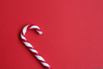 Candy canes isolated on red background. Copyplace, space for text and logo.