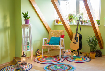 Modern maximalism or maximalist home decor interior design concept, different colorful things in home, vintage chair, flower stand, bright green wall.