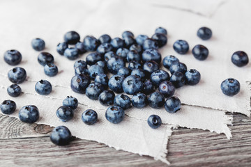 Blueberries lie on homespun tablecloth. Rustic cozy background with healthy food. Fresh-gathered berries full of vitamins, good for diet nutrition and healthy meals.
