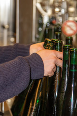 in a winery automatically filled bottles are taken off from the filling station