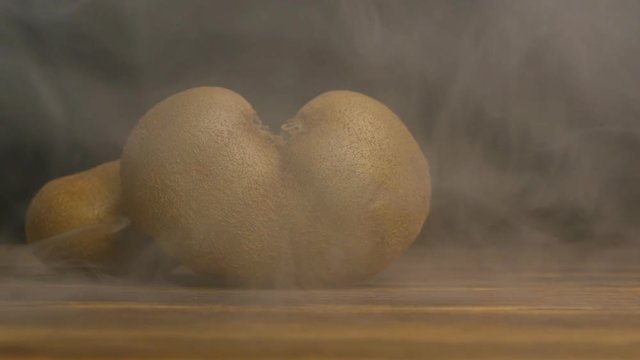 Juicy kiwi fruit butterfly variety from which blows cool and fresh, on a black background, close-up, slow motion