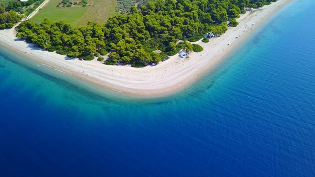 Aerial bird's eye video taken by drone of exotic seascape and sandy beach with turquoise clear waters and pine trees, Rovies, North Evoia island, Greece