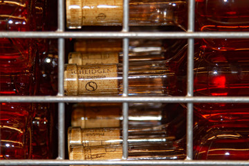 bottles with light pink wine are stored in a skeleton box