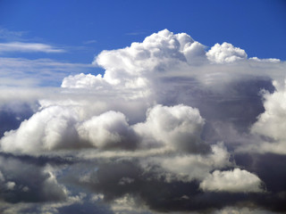 Stormy clouds gather to form beautiful cloud formations over dark blue sky.
