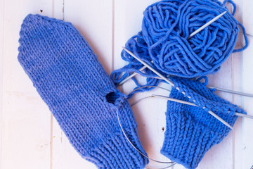Knitting of the mittens. Woolen yarn ball, needles