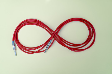 Red audio cable is in the form of the figure 8 on the pale yellow background
