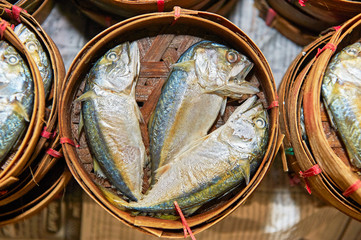 Three common thai mackerel fishes in a woven bamboo basket for sale at the Klong Toey Market in Bangkok, Thailand