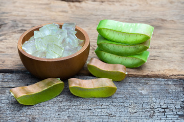 Fresh aloe vera plant, stem slices and gel on wooden background, skin therapy concept - 250671282