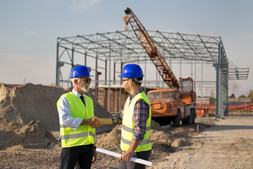 Engineers shaking hands on construction site