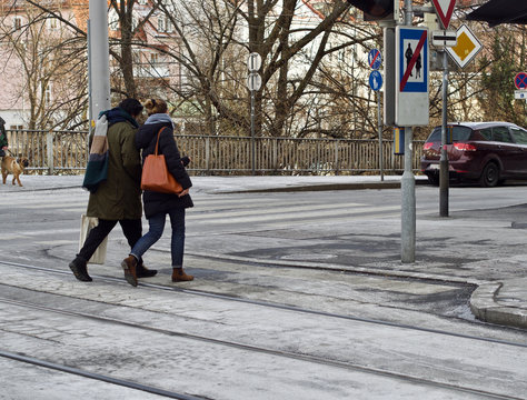 Ein gl&uuml;ckliches Paar &uuml;berquert eine Stra&szlig;e in der Innenstadt