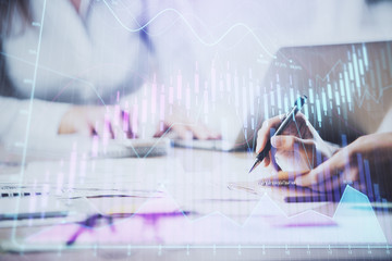 Close up of hands writing with double exposure of business charts. Financial concept.