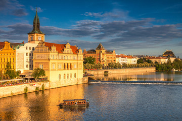 Vltava river and waterfront of the old town with the theater in Prague at sunset, Czech Republic,...