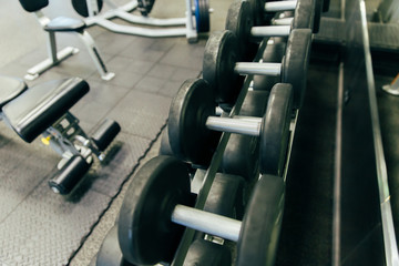 Fototapeta na wymiar Rows of dumbbells in the gym with hign contrast and monochrome color tone