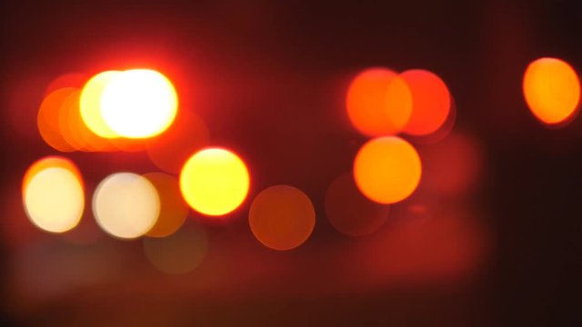 Defocused yellow and red flashing lights of firetruck at night. Emergency response. Handheld shot with stabilized camera.