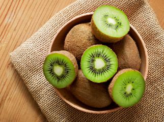 Delicious ripe kiwi fruits in a wooden bowl. Top view scene, healthy eating or healthy lifestyle....