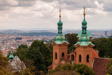 Towers of Cathedral of Saint Lawrence (Prague) with the city of Prague in the background, on an...