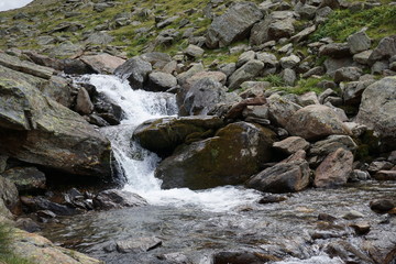 Naklejka na ściany i meble Bachlauf/ kleine Wasserfälle über Steine in den Bergen