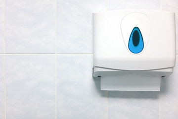 Soft focus paper towel dispenser on a granite wall in the bathroom