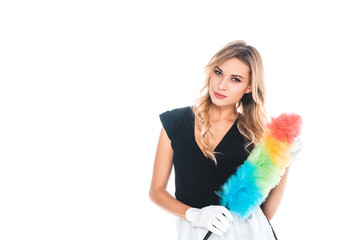 attractive blonde housemaid in black uniform, apron with multicolored broom isolated on white