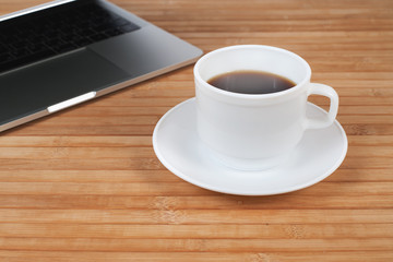 Laptop and coffee cup on wooden table, warm retro style
