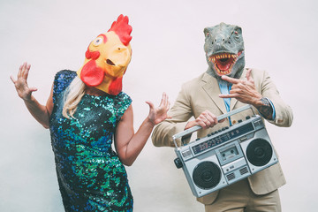 Crazy senior couple wearing chicken and t-rex mask while dancing outdoor - Mature trendy people...