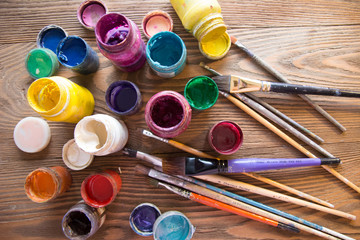 Multicolored plastic cans with paints. Artist workplace background. Old dirty Paints background....