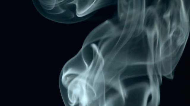  Thin trickle of white smoke slowly rising graceful twists on black background blowing from bottom to top. Close Up, Slow motion