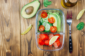 Healthy meal prep containers on wooden backgound.