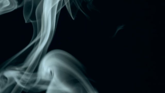  Trickle of white smoke slowly rising graceful twists on black background blowing from bottom to top. Close Up, Slow motion