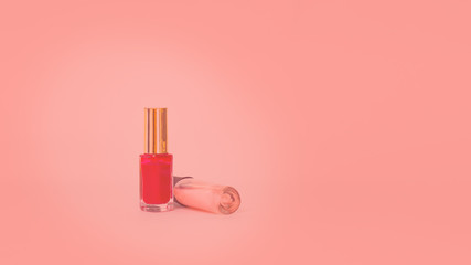 Two glass bottles with nail polish. Isolated object on coral background. Tone. Nail polish. Beauty. Manicure. Colour. Coral. Copy space. Horizontal