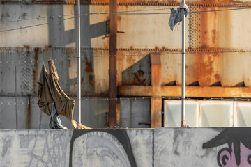 War and political refugees concept. Barbed wire fence detail, torn clothing strips from escape route. European and American closure, closed borders. African, Mexican and middle eastern migration flux.