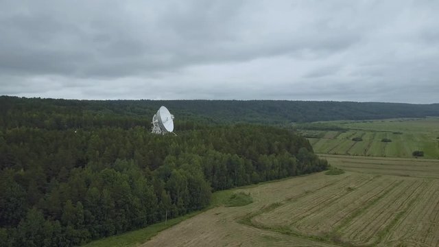 Aerial view. Flight around radio telescope in observatory. Greean forest and glade.