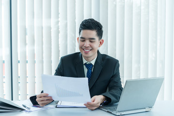 Fototapeta premium Young asian employee working at laptop during working day in office,Businessman happy with smile in the office,thailand people at company
