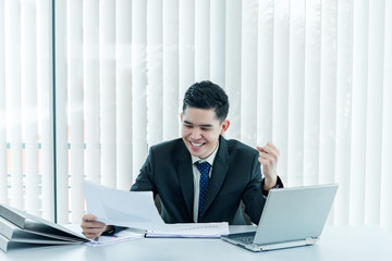 Young asian employee working at laptop during working day in office,Businessman happy with smile in the office,thailand people at company