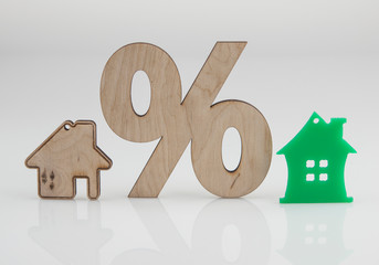 wood percent sign and house shape on white background. The concept of price changes on the real...