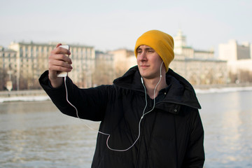 Portrait of a cheerful man taking selfie in the park