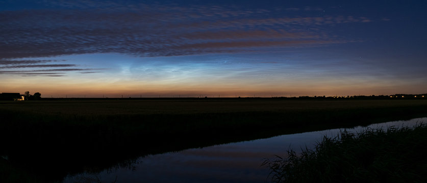 Panorama of noctilucent clouds (NLC), night clouds over the wide open dutch landscape.