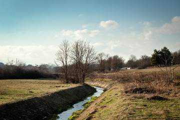 Park by the river in memorial park Sumarice in Serbia, winter cloudy day, sunset.