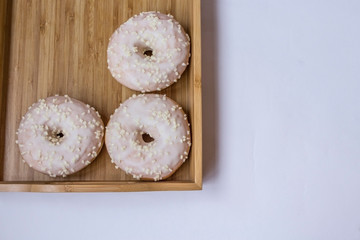 Three donuts on the bamboo tray. Copy space. Place for text
