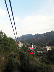 Mt.Gozaisho, JAPAN - January 23, 2019: Ropeway Lifts Red cable car pass through lot of trees in winter