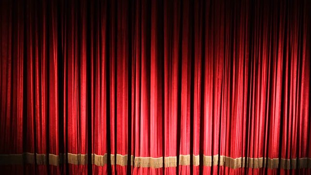 Red closed curtain with light spots in a theater or opera