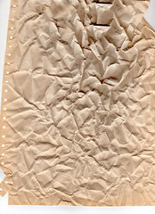 Beige heavily crumpled paper background or texture