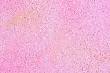 Pink decorative plaster textured background with yellow and beige abstract spots and grunge surface. Empty neutral pink backdrop with decorative plastered texture and aged effect  